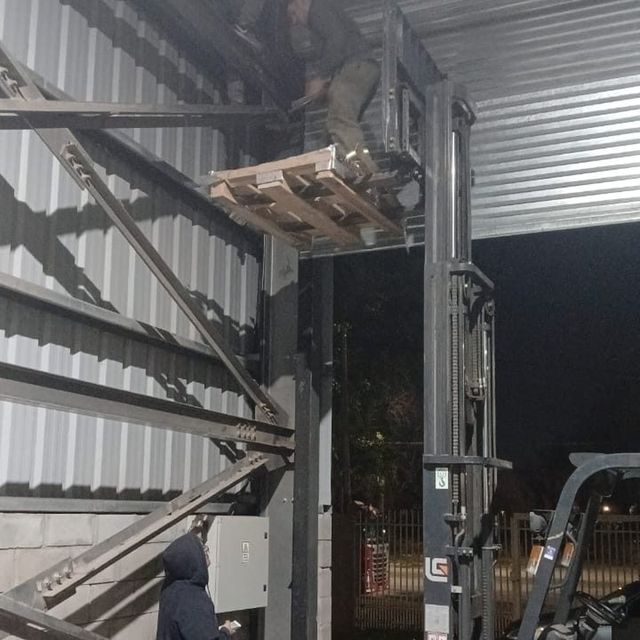 Reparación de cortina industrial de galpón con autoelevador, de noche
